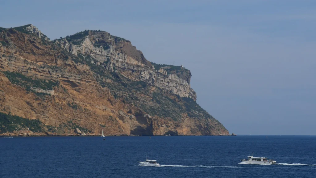 Bateaux de plaisance naviguant au large d'une côte rocheuse