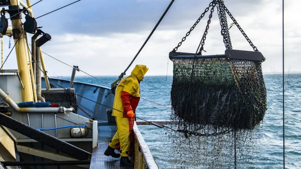 Pêcheur en ciré jaune sur le pont d un bateau de pêche